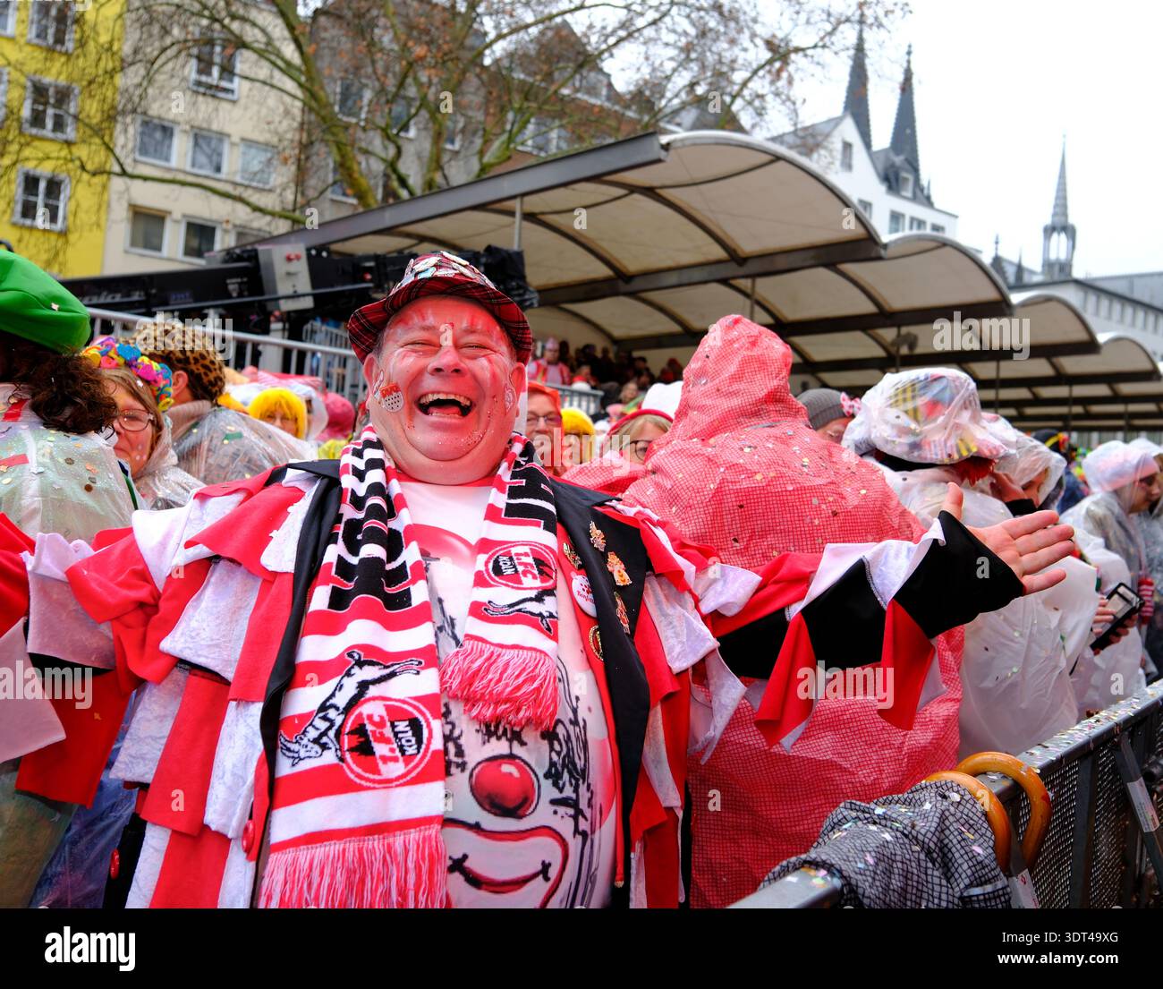 Lächelnder Karnevalsfreunde in bunten Kostümen, umgeben von einer lebhaften festlichen Menge, die die Weiberfastnacht am Alten Markt in Köln markiert. Deutschland Stockfoto