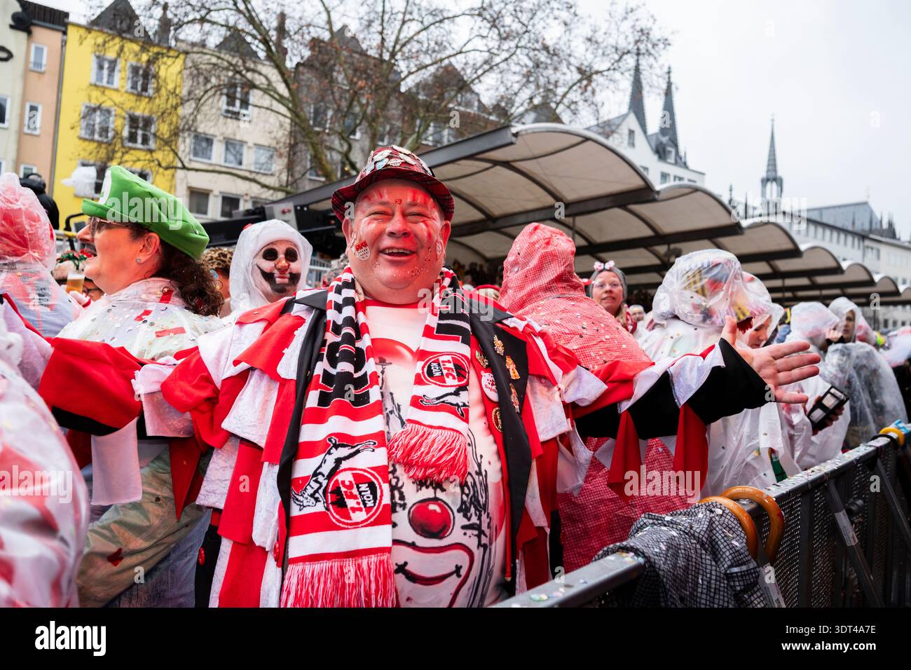 Lächelnder Karnevalsfreunde in bunten Kostümen, umgeben von einer lebhaften festlichen Menge, die die Weiberfastnacht am Alten Markt in Köln markiert. Deutschland Stockfoto