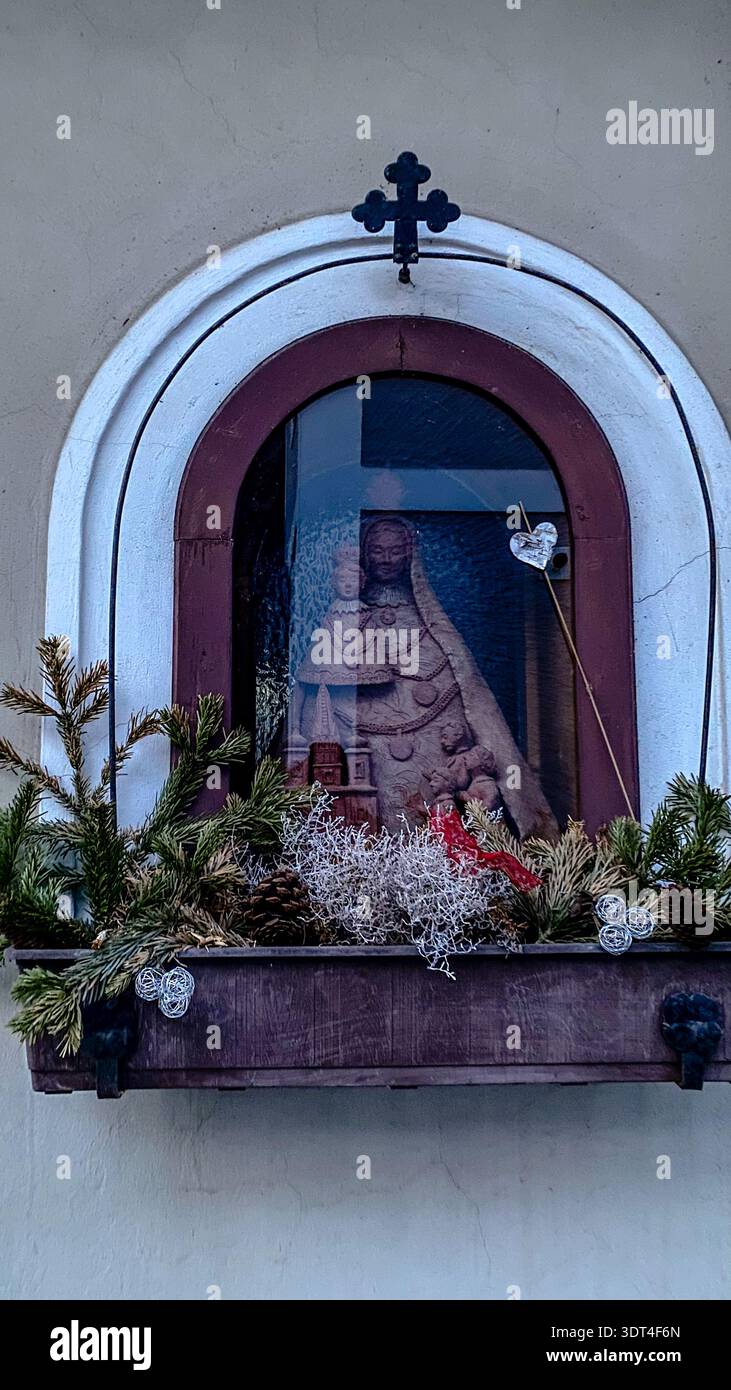 Kleiner religiöser Schrein mit Statue in der Fensternische an der Hausfassade in Waidhofen an der Ybbs, Österreich. Stockfoto