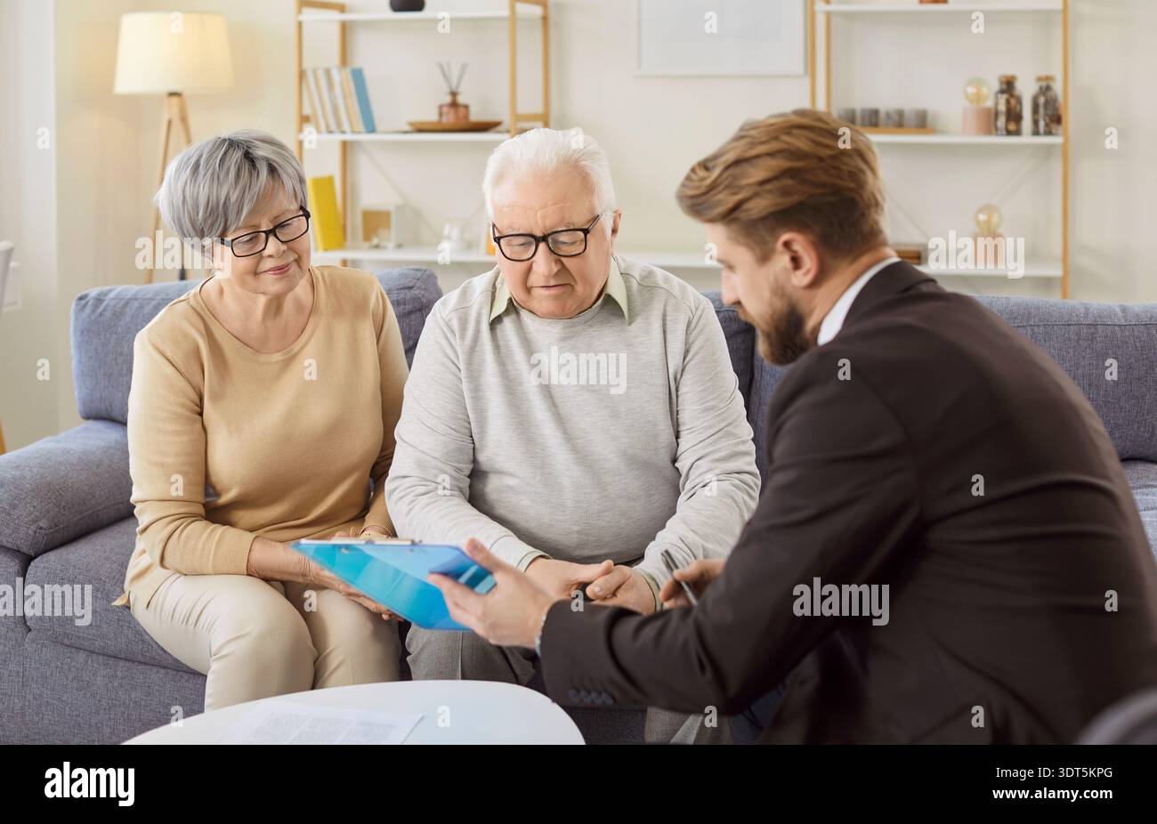 Der Finanzberater erklärt älteren Ehepaaren vor der Unterzeichnung Vertragsdetails Stockfoto