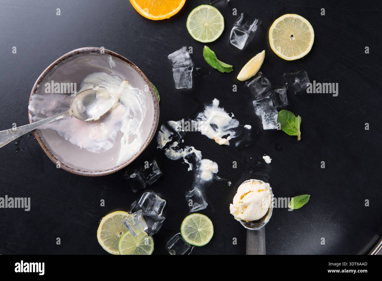 Süße Dessertreste mit Zitrusscheiben und Eis auf dem Tisch Stockfoto