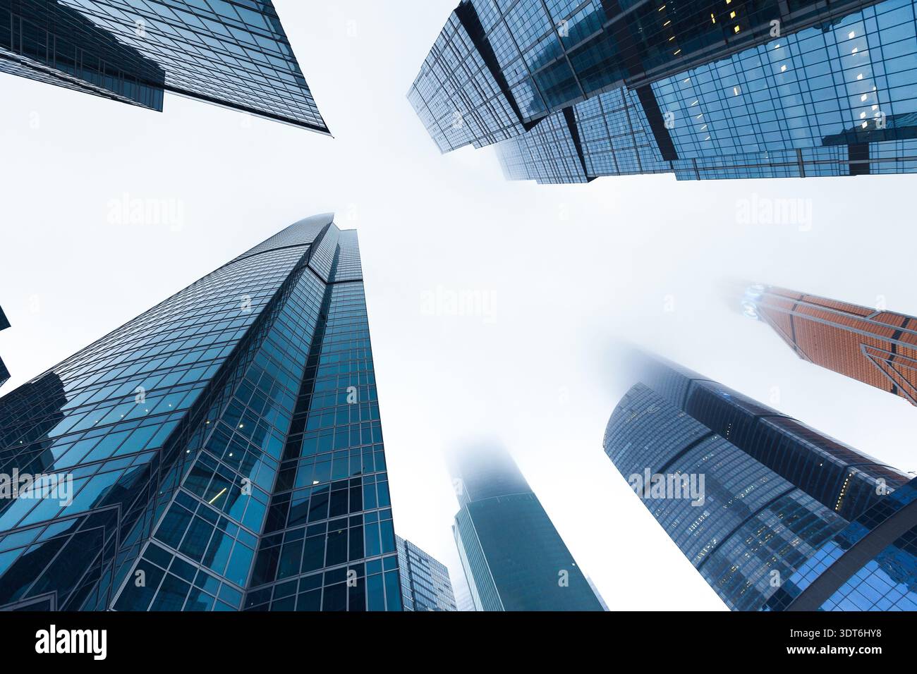 Sammlung von urbanen Wolkenkratzern aus einem niedrigen Winkel an einem nebeligen Tag in der Stadt Stockfoto