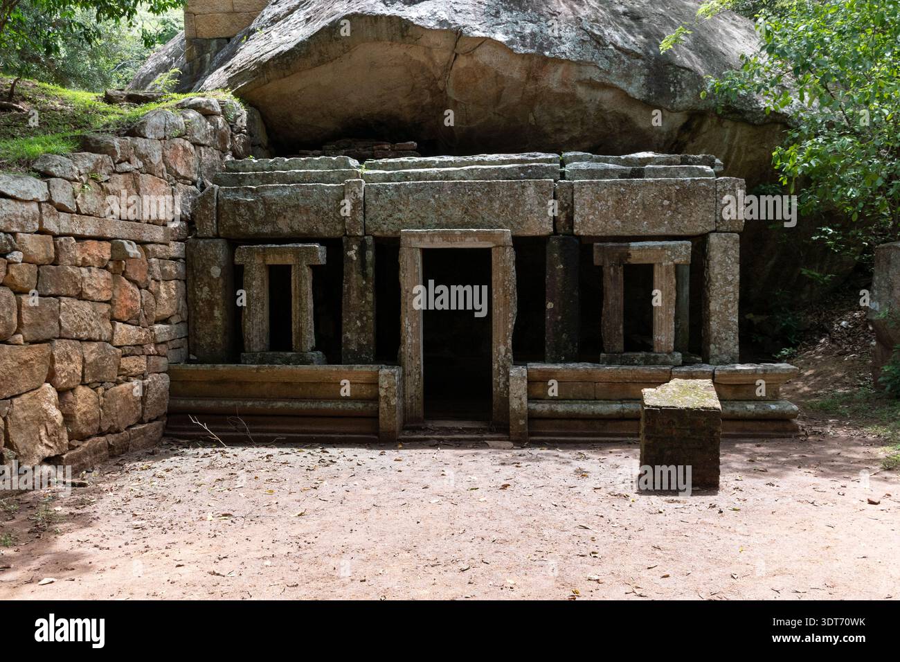 Eine horizontale Aufnahme auf Augenhöhe erfasst die antiken Steinruinen eines buddhistischen Klosters in Kaludiya Pokuna, Mihintale, Sri Lanka. Stockfoto