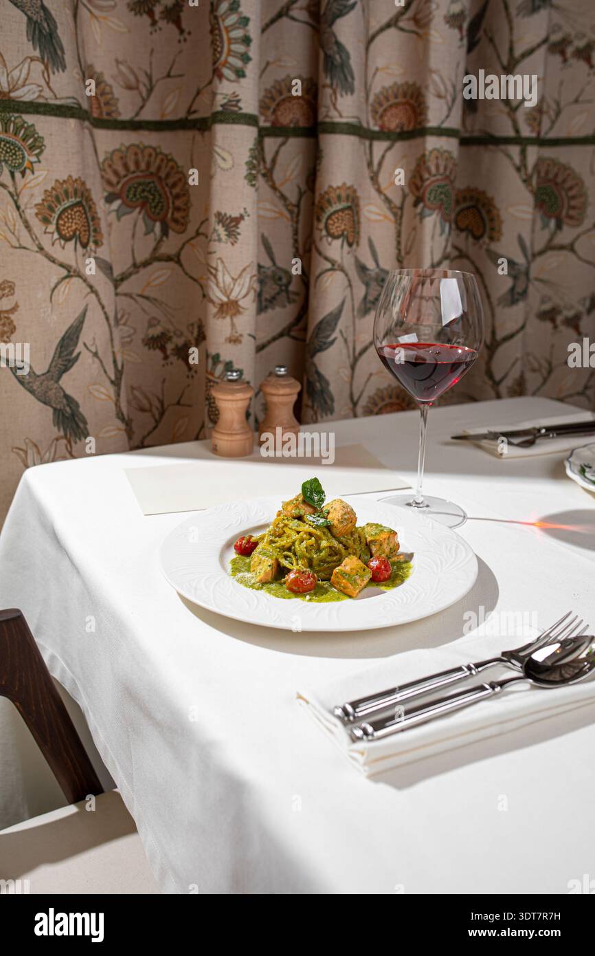Grüne Pesto-Pasta mit Lachs und Rotwein Stockfoto