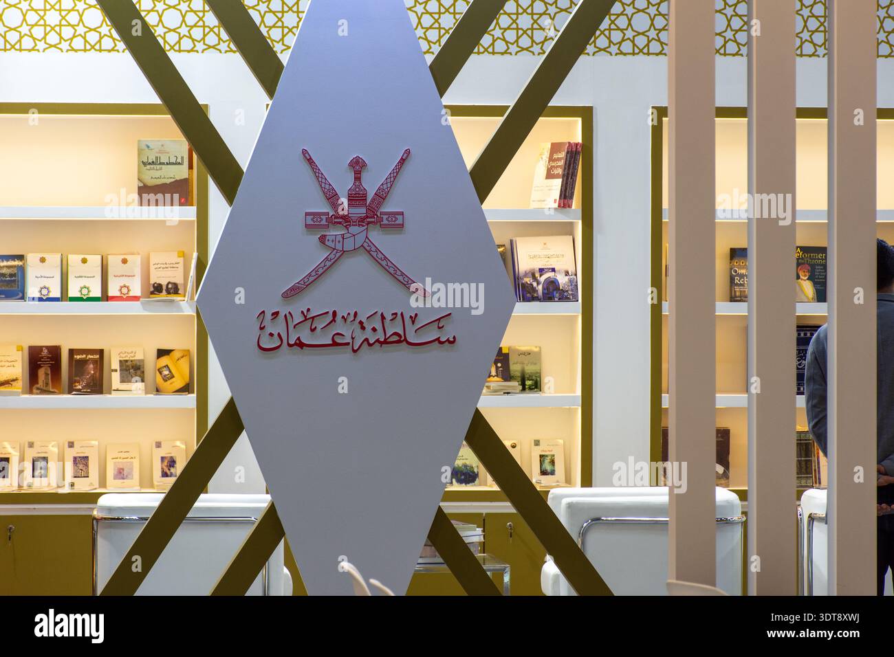 Ein Schild mit dem nationalen Emblem und der arabischen Kalligraphie des Sultanats Oman auf der Abu Dhabi International Book Fair, VAE. Stockfoto