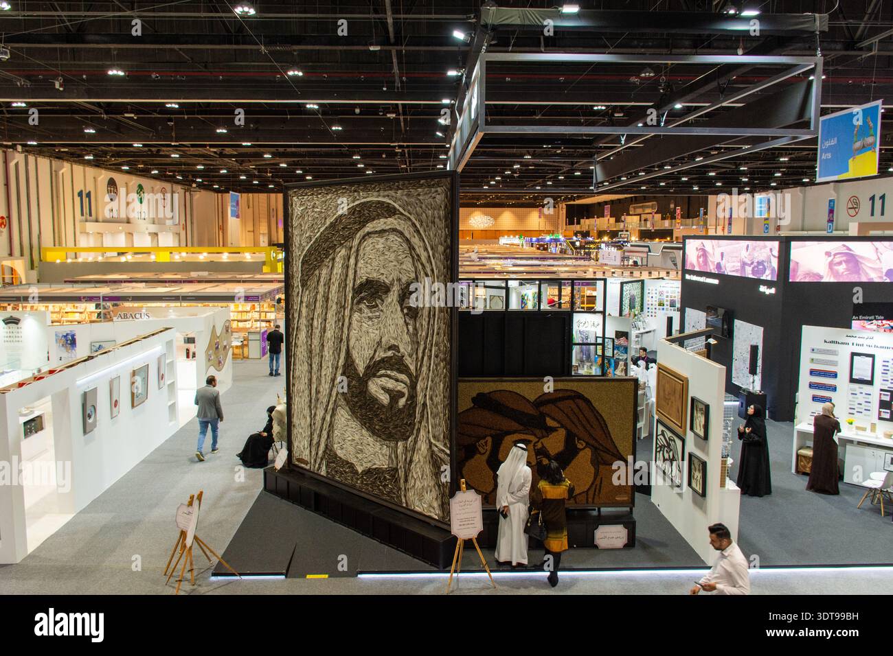 Besucher sehen große Porträtwerke arabischer Führer auf der Abu Dhabi International Book Fair, VAE. Stockfoto
