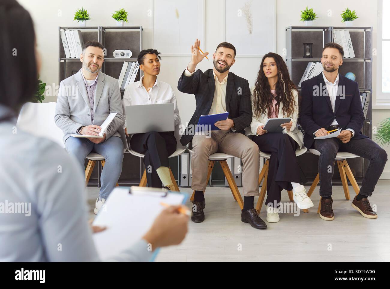 Vielfältige Gruppe von Fachleuten, die im Büro interaktiv diskutieren Stockfoto