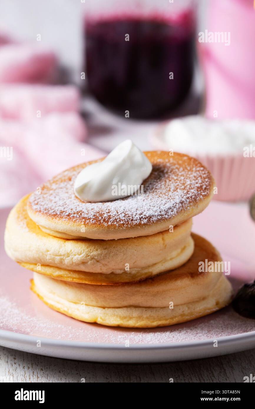 Flauschige Pancakes, japanische Souffle Pancakes serviert mit Sahne und Johannisbeergelee. Stockfoto