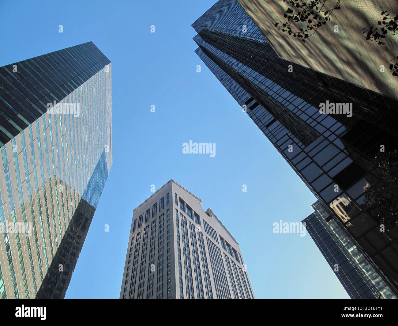 Dramatische Aufwärtsperspektive mehrerer Wolkenkratzer, die eine geometrische Komposition gegen den Himmel bilden. Stockfoto