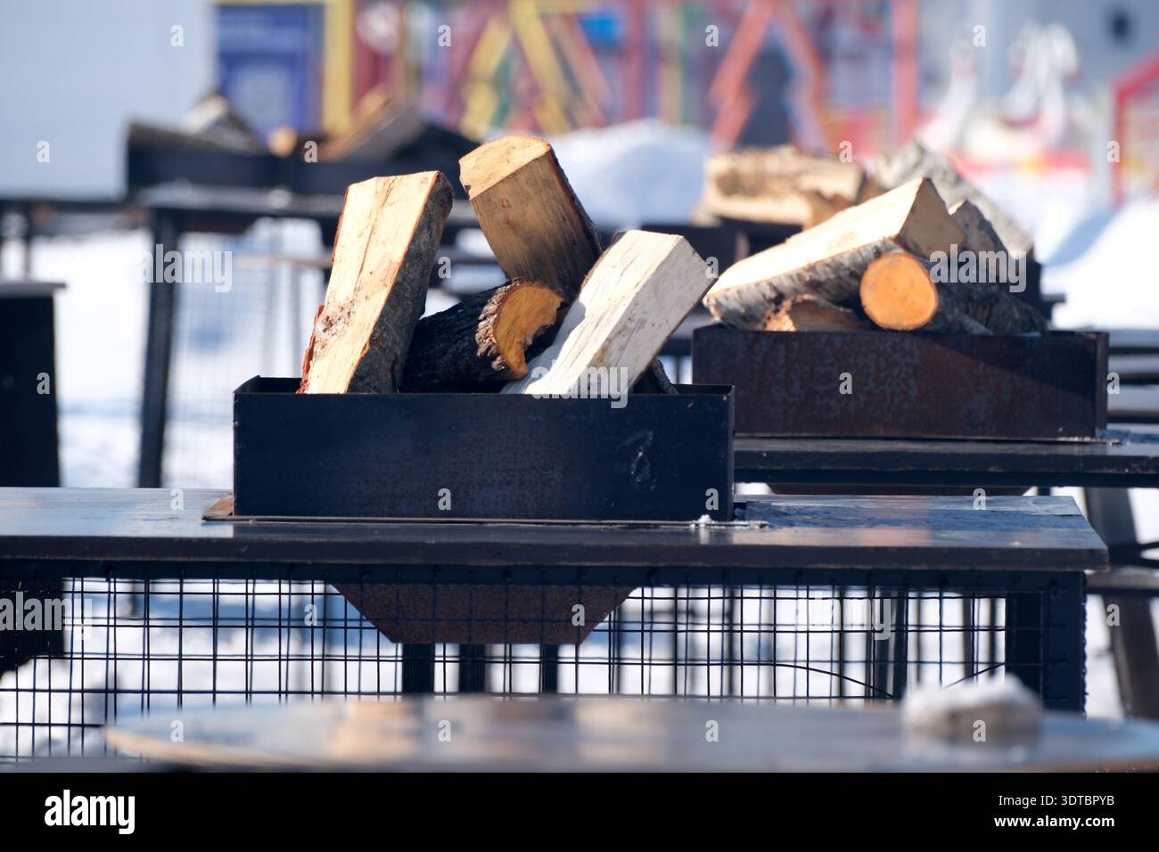 Die Winterversammlungen zeigen eine warme Atmosphäre mit gestapelten Baumstämmen, die auf ein fröhliches Feuer warten. Stockfoto