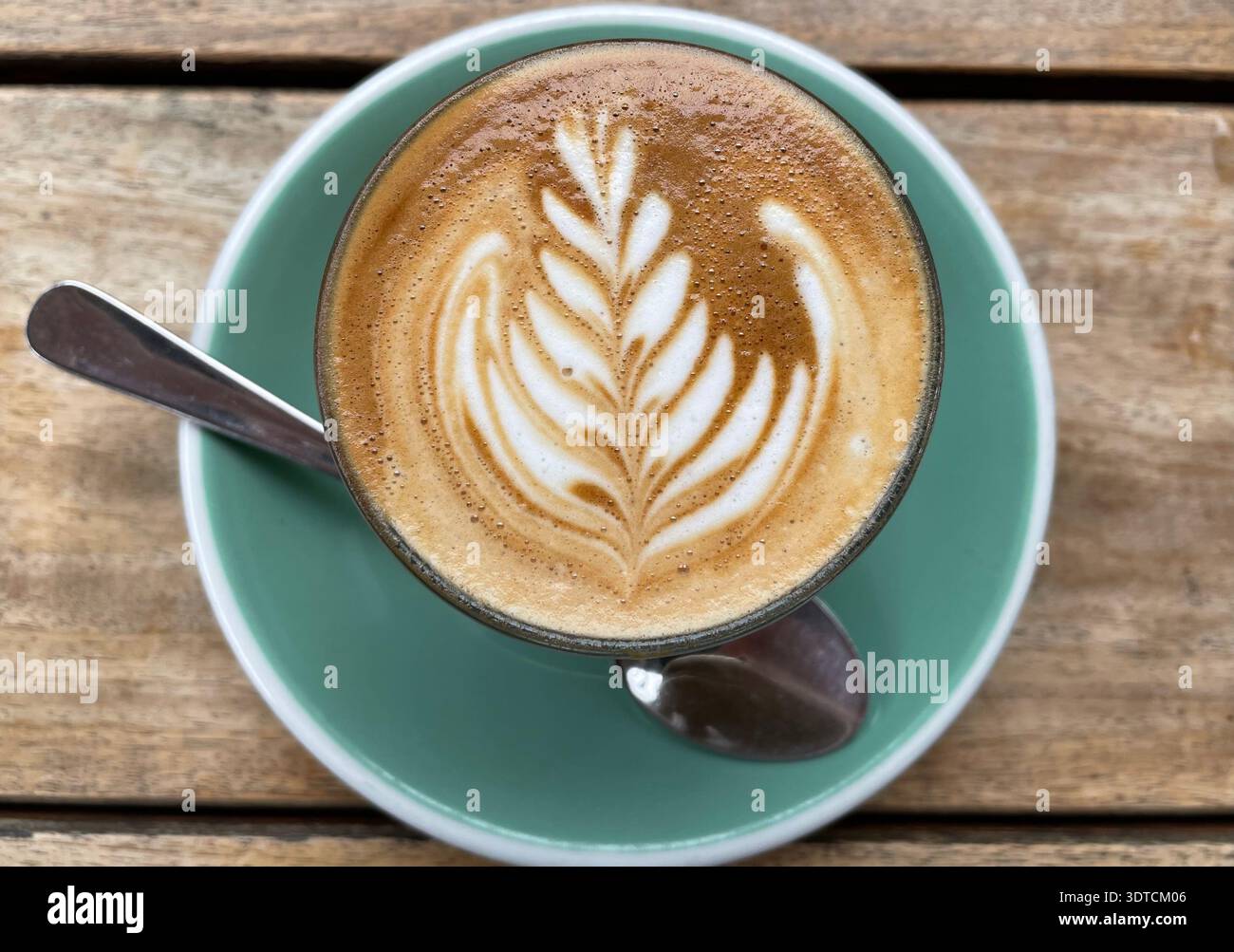 Ein Farnblatt wird in den Schaum eines Flat White Coffee in Odette’s Restaurant in Auckland, Neuseeland, geformt. Stockfoto