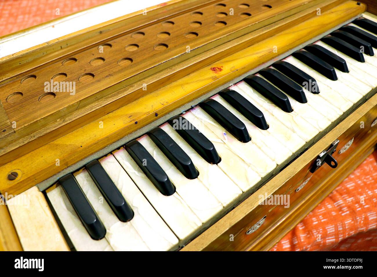 Eine detaillierte Nahaufnahme eines traditionellen indischen Harmoniums mit schwarz-weißen Tasten und Holzstruktur Stockfoto