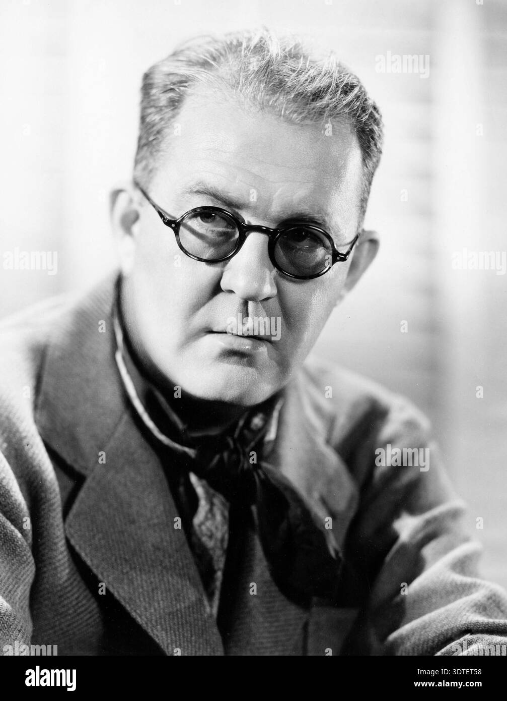Dieses auffällige Schwarz-weiß-Porträt, wahrscheinlich aus den 1940er Jahren, fängt den mit dem Academy Award ausgezeichneten amerikanischen Regisseur John Ford ein. Ford ist bekannt für seine klassischen Westler und trägt eine runde Brille, die ein besinnliches und ernstes Verhalten ausstrahlt. Stockfoto