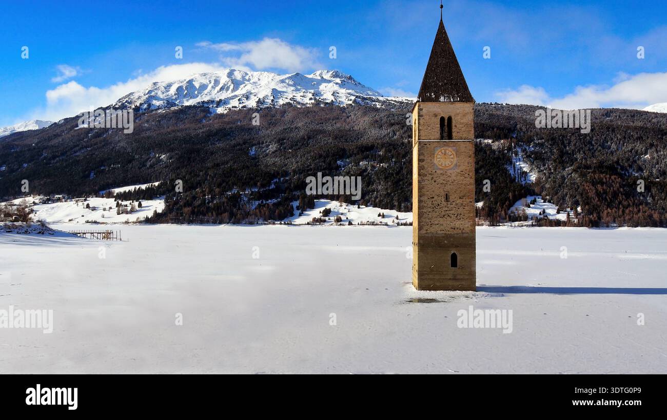 Gesunkener Glockenturm des Reschensees unter blauem Winterhimmel. Ein klarer, sonniger Wintertag am Reschensee in Südtirol, Italien. Stockfoto