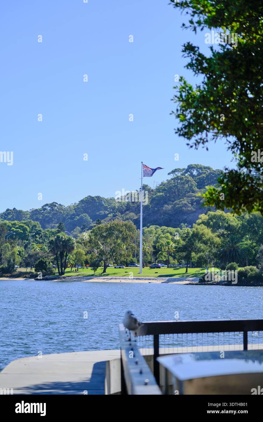 Ein ruhiger vertikaler Schuss, der die australische Flagge einfängt, die stolz gegen einen klaren blauen Himmel winkt. Stockfoto