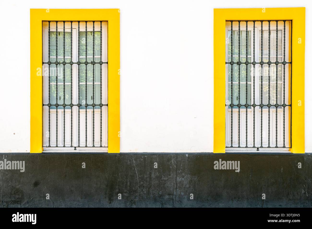 Minimale Fassade mit gelb gerahmter Fenstersymmetrie Stockfoto