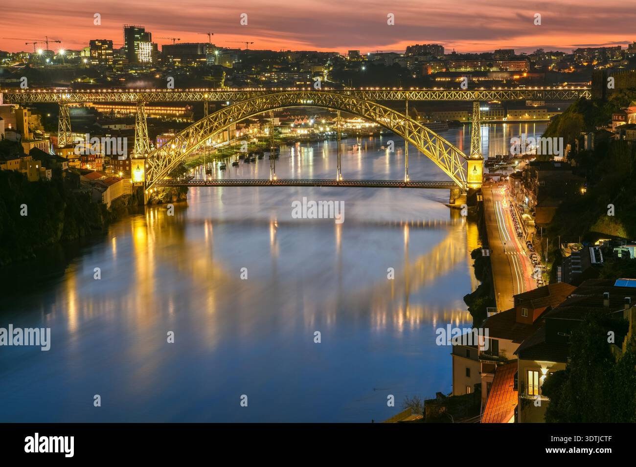 Blick auf die Brücke Dom Luis I und den Stadtteil Bairro da Ribeira in Porto, Portugal, in der Abenddämmerung. Stockfoto