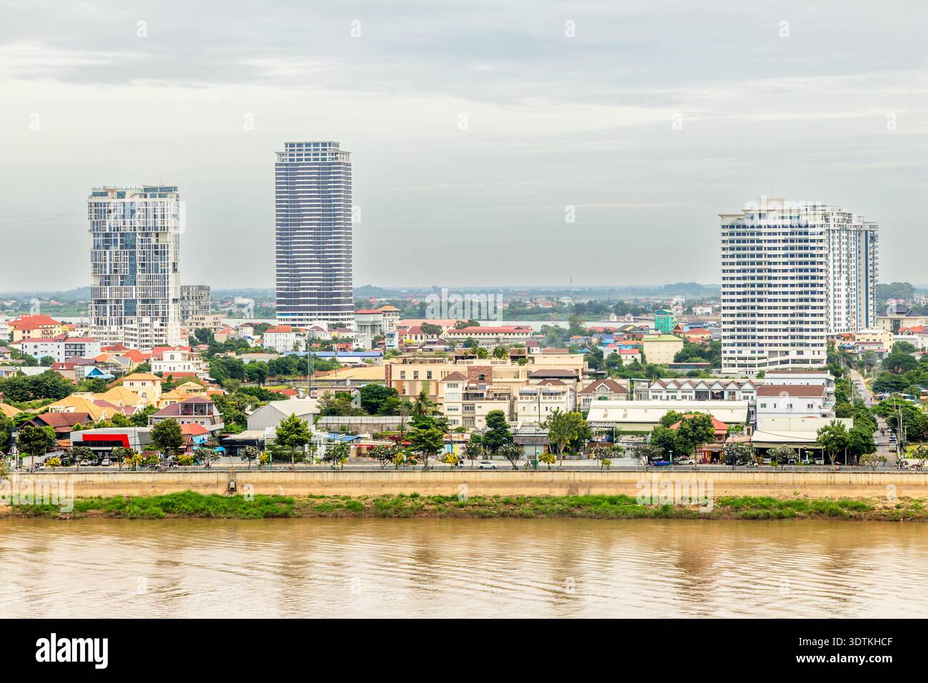 Moderne Apartmenthäuser, die sich über traditionellen Häusern am Tonle-SAP-Ufer in Phnom Penh, Kambodscha, erheben Stockfoto
