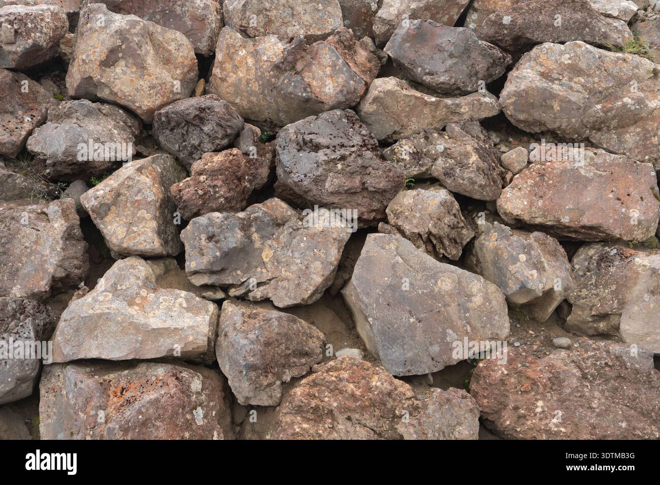 Felswand aus großen, warmen Felsblöcken. Hintergrundstruktur. Stockfoto