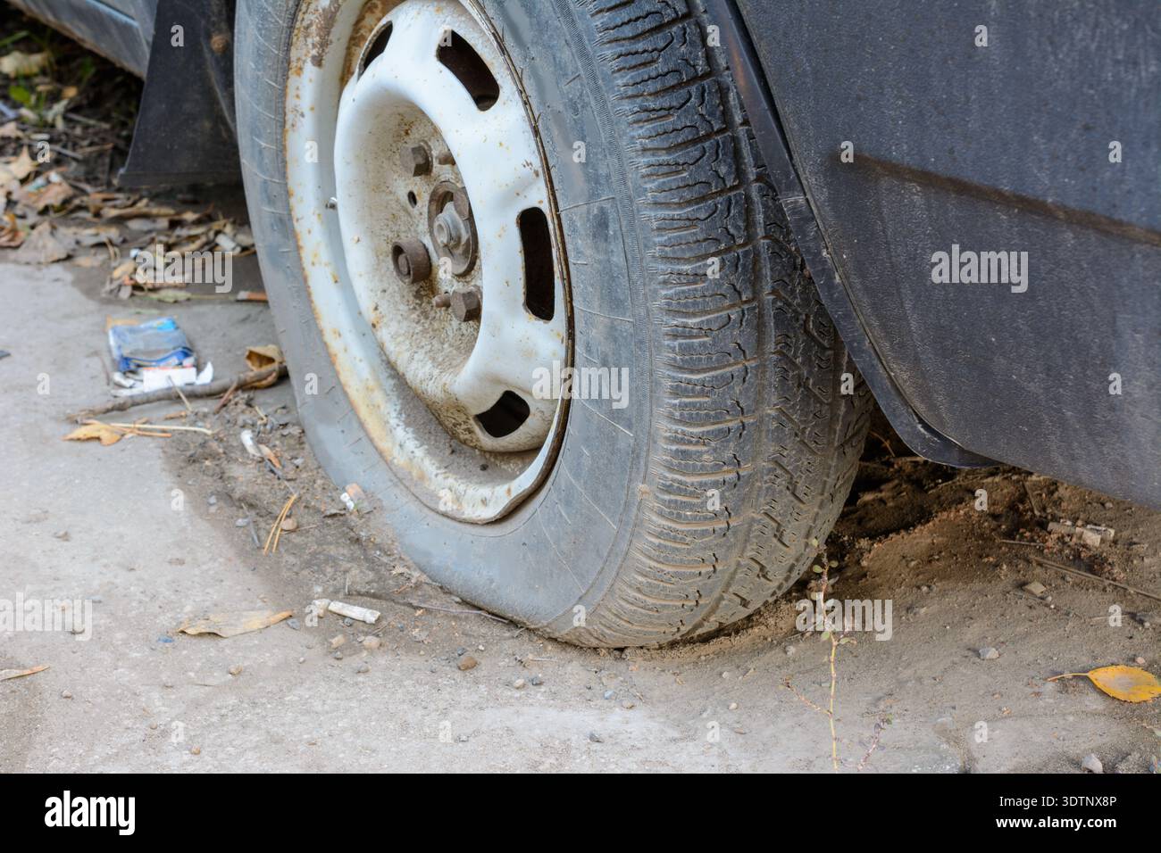 Close-up beschädigten Reifens. Das Rad der PKW-Reifen lecken. Reifenpanne warten auf die Reparatur. Verlassenes Auto auf dem Parkplatz. Stockfoto