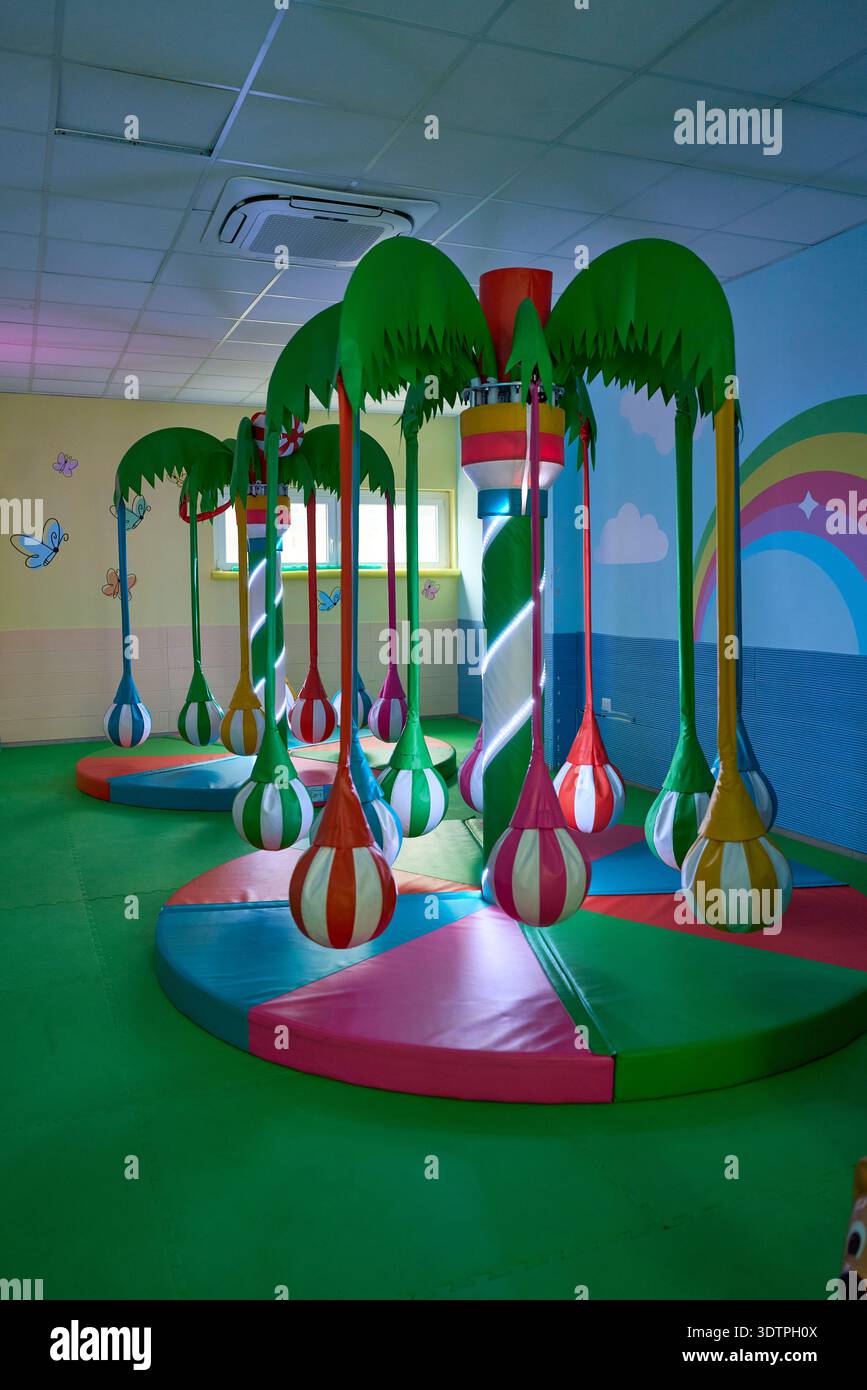 Farbenfroher Indoor-Spielplatz für Kinder mit Palmenschmuck und weichen Spielgeräten, Cosenza, Kalabrien, Italien Stockfoto