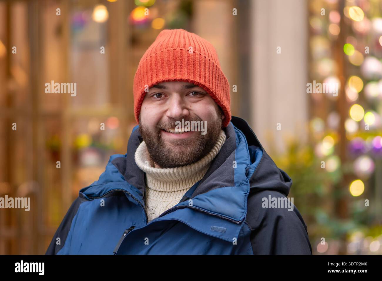 Porträt einer erwachsenen Person in warmer Kleidung vor Ladenbeleuchtung Stockfoto