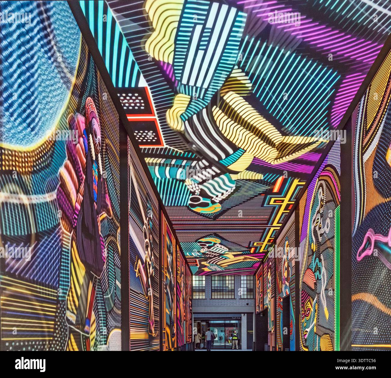 Lebendige digitale Kunst-Tunnelinstallation im Outernet London mit farbenfrohen abstrakten Designs und futuristischer immersiver Architektur. Stockfoto