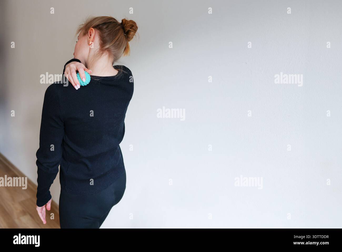 Athlet lindert Schulterschmerzen mit Massageball. Fitness-Erholung und Körperpflege-Lifestyle-Image. Stockfoto