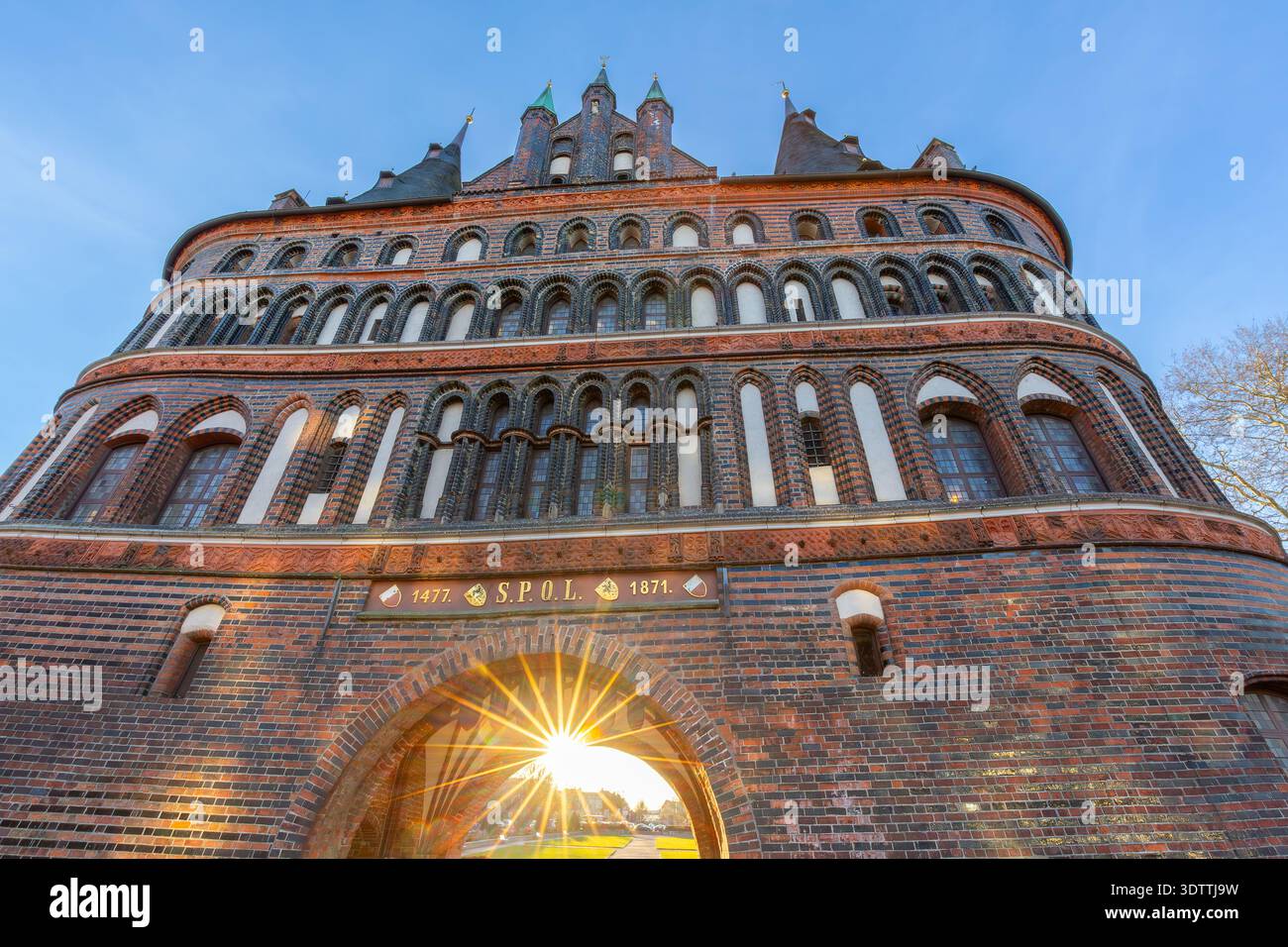 15. Jahrhundert Backsteingotisches Stadttor Holstentor / Holstentor in der Hansestadt Lübeck bei Sonnenuntergang im Winter/Frühling, Schleswig-Holstein, Deutschland Stockfoto