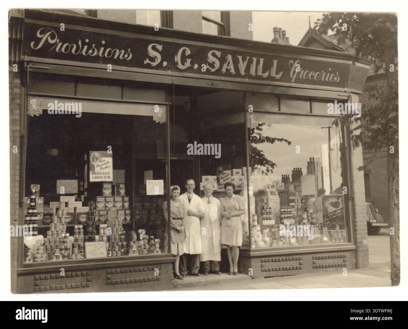 Vintage-Foto aus den 1930er-/1940er-Jahren-Ära, Supermarkt, S.C. Savill's - mit Eigentümer/Besitzer und Personal, Waren im Fenster 1930er 1940er-Jahre UK ausgestellt Stockfoto