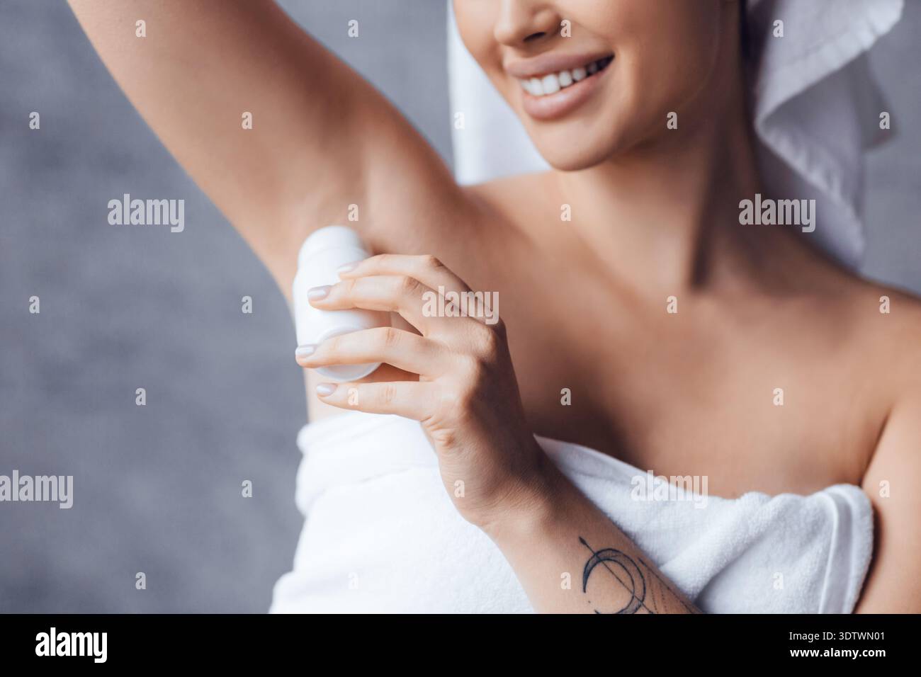 Frau, die das Produkt unter dem Arm im Badezimmer nach der Dusche anwendet Stockfoto