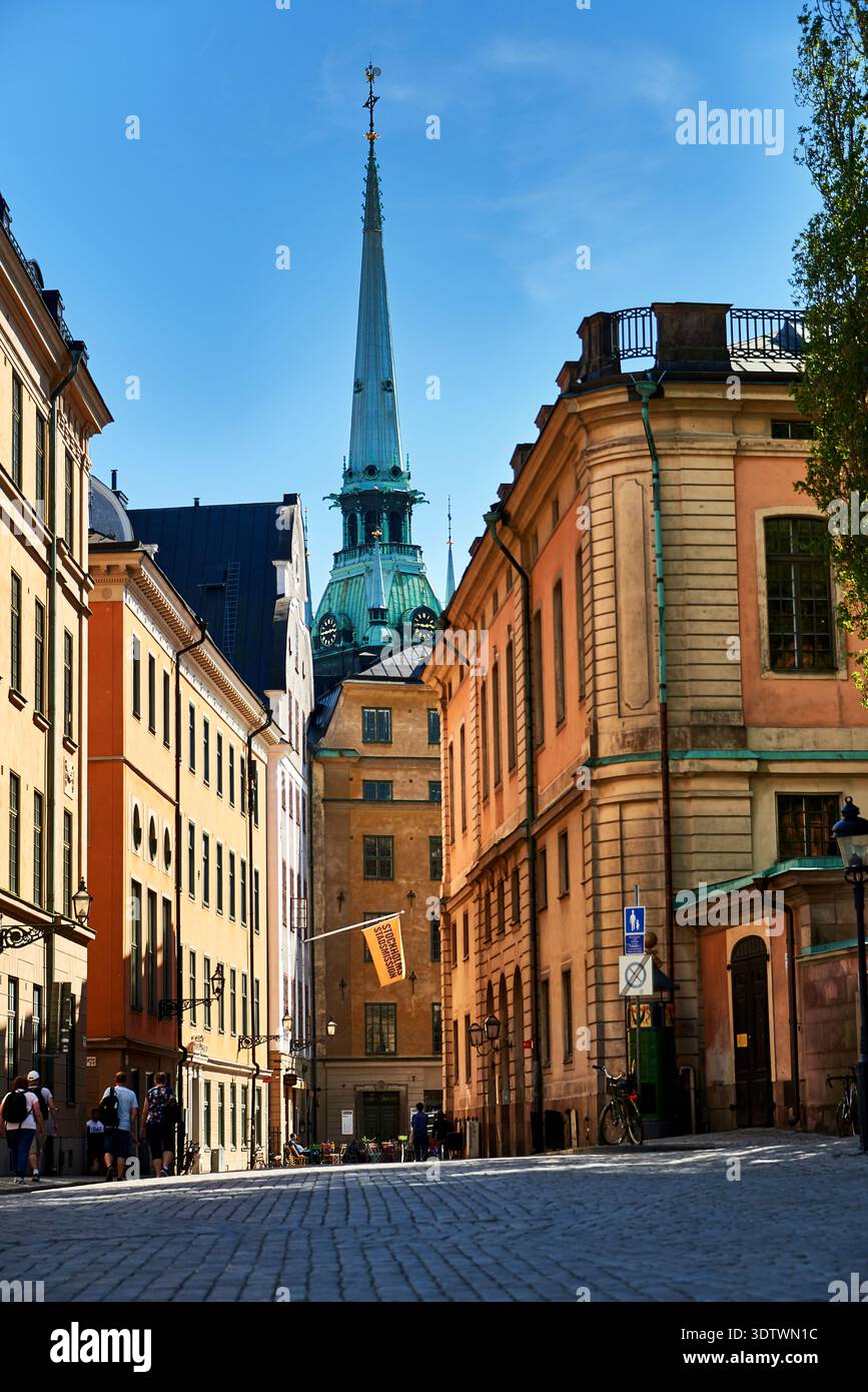 Ein bezaubernder Blick auf die Straße in Gamla Stan (Altstadt), Stockholm, Schweden, mit farbenfrohen historischen Gebäuden entlang einer schmalen Kopfsteinpflasterstraße. Das Symbol Stockfoto