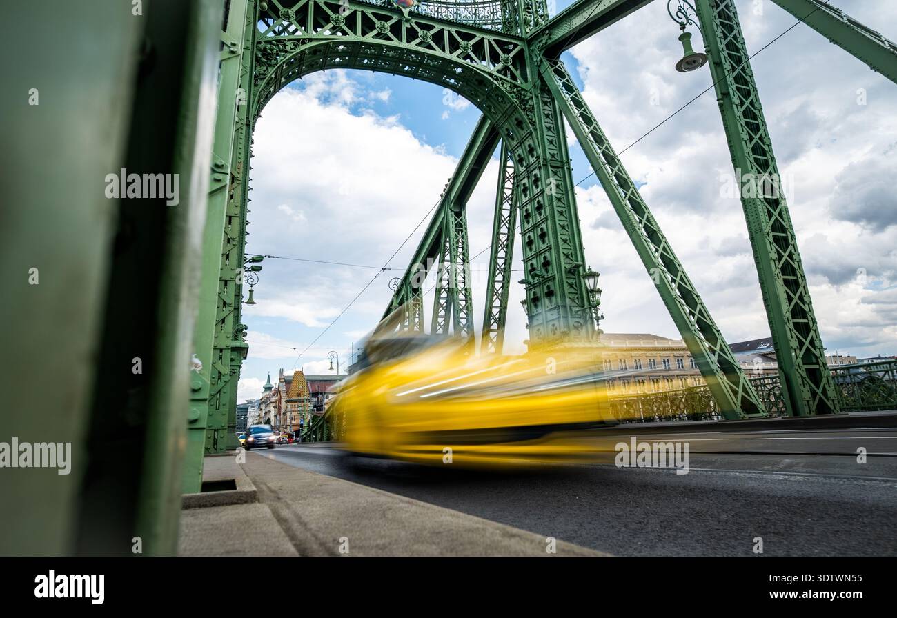 Das gelbe Taxi fährt schnell an Einer Retro-Brücke in der rauschenden Stadt vorbei Stockfoto