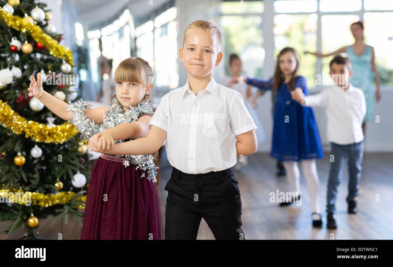 Jugendliche in eleganten Outfits üben im Weihnachtsstudio Partnertanz Stockfoto