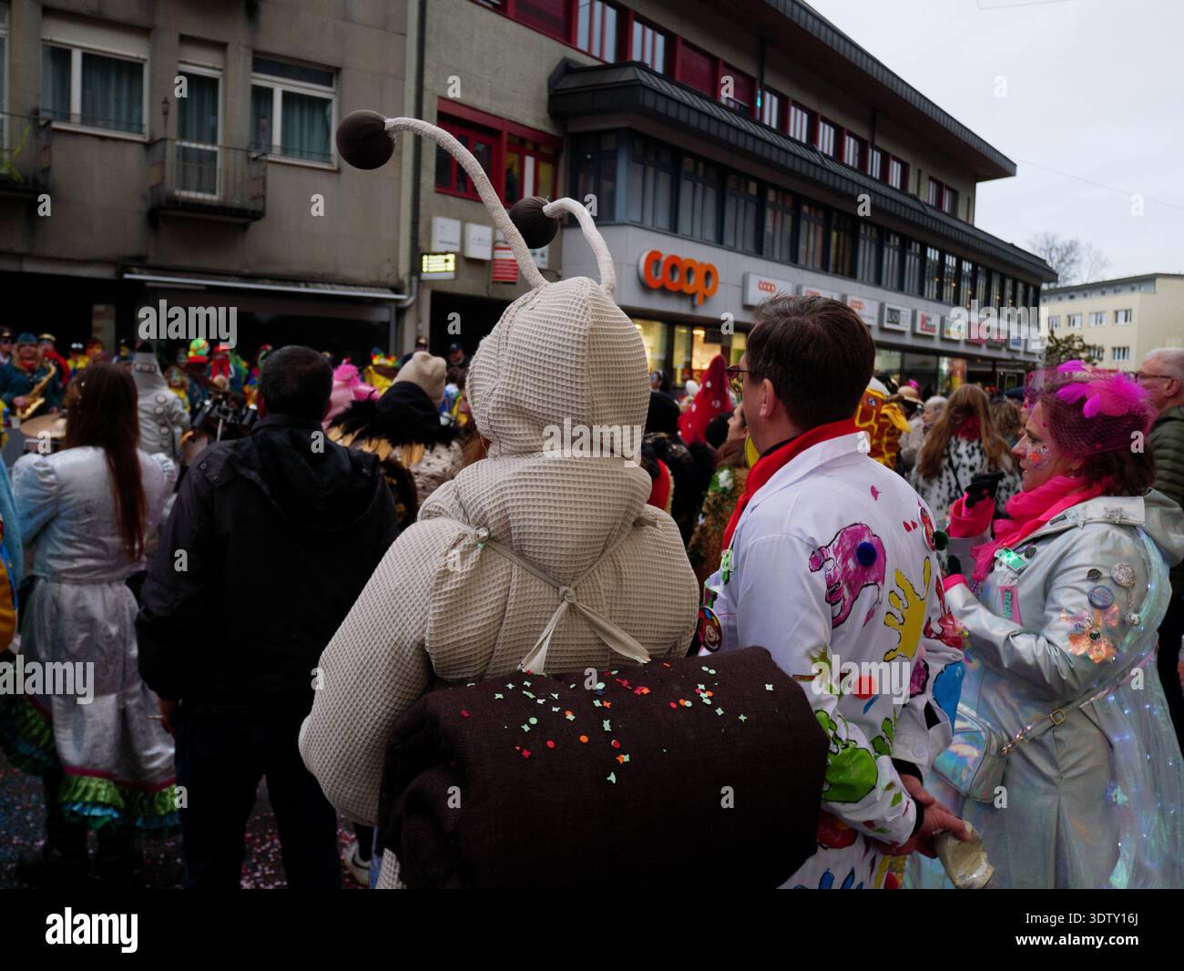 Langenthal, Bern, Schweiz. Februar 2026. Fasnacht Karneval in der Stadt. Individuum, gekleidet als Schnecke, steht in einer Menge während einer Parade mit Stockfoto