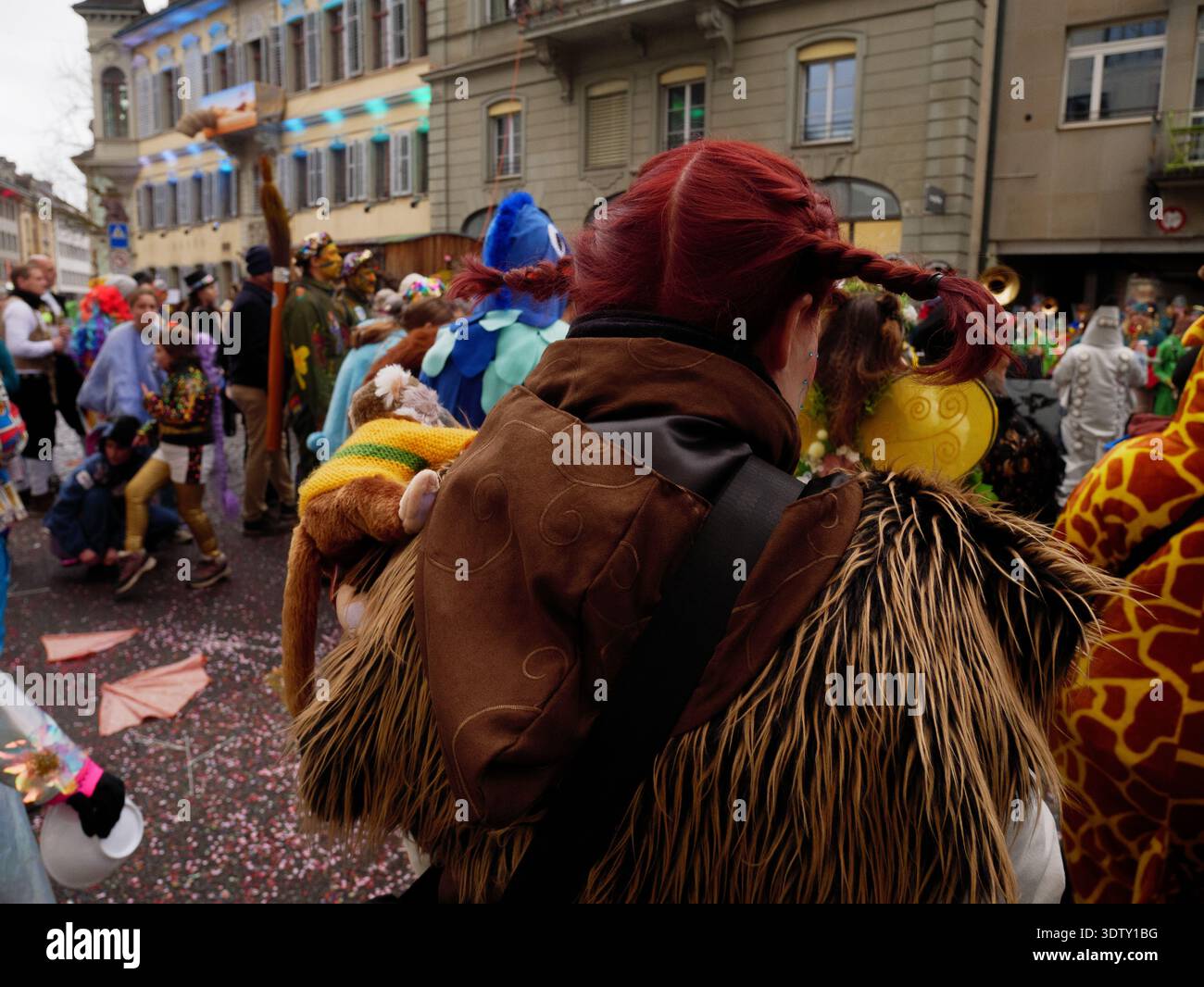 Langenthal, Bern, Schweiz. Februar 2026. Fasnacht Karneval in der Stadt. Eine Person, die ein Tierkostüm trägt, steht unter einer Menschenmenge auf einer Straße Stockfoto