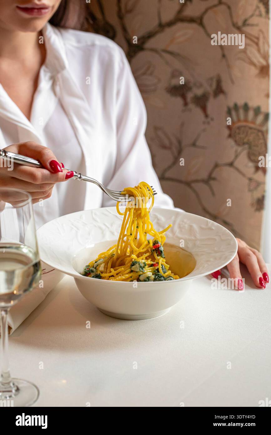 Frau isst Pasta in elegantem Restaurant Stockfoto