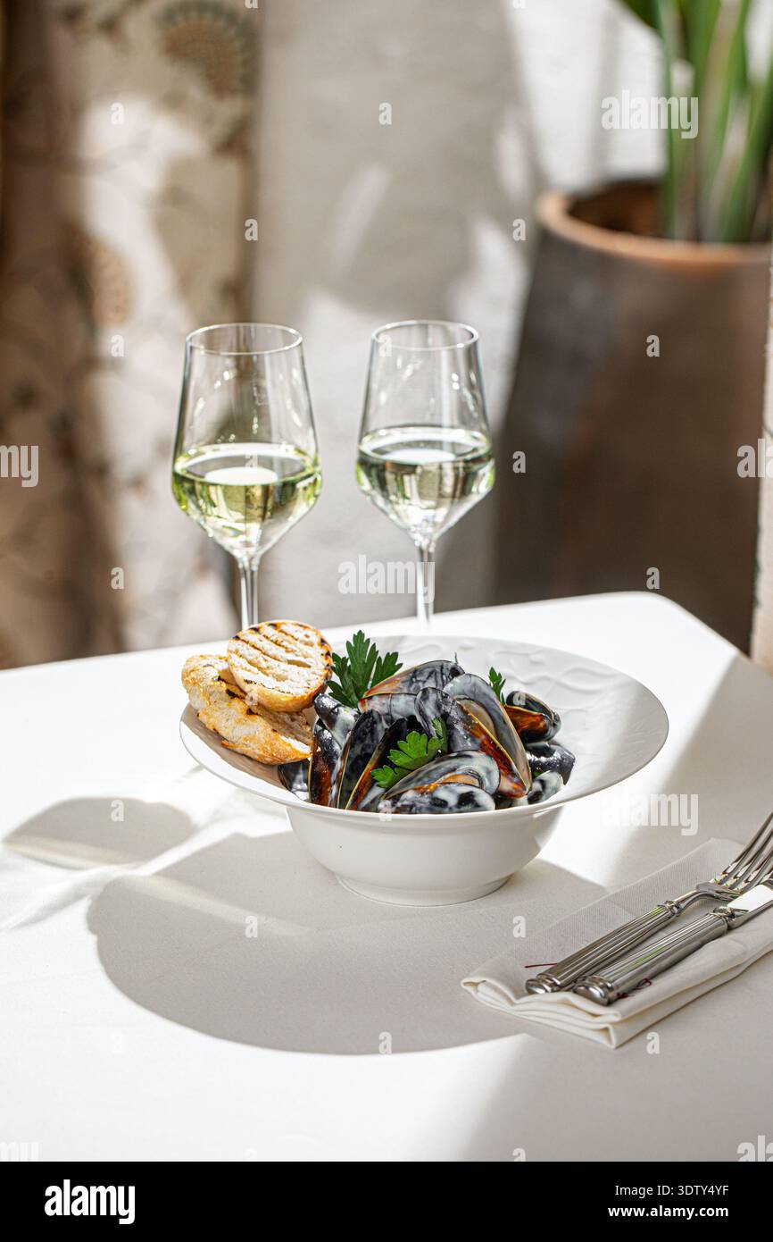 Gedämpfte Muscheln mit Brot und Weißwein Stockfoto