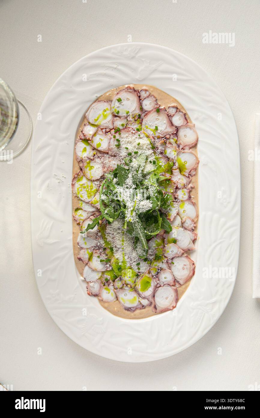 Octopus carpaccio mit Rucola und Parmesan Stockfoto
