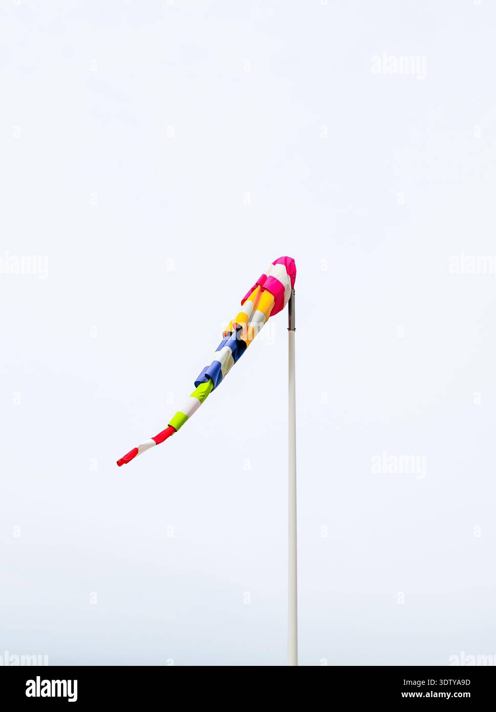 Bunte Wetterfahne vor neutralem Hintergrund. Stockfoto