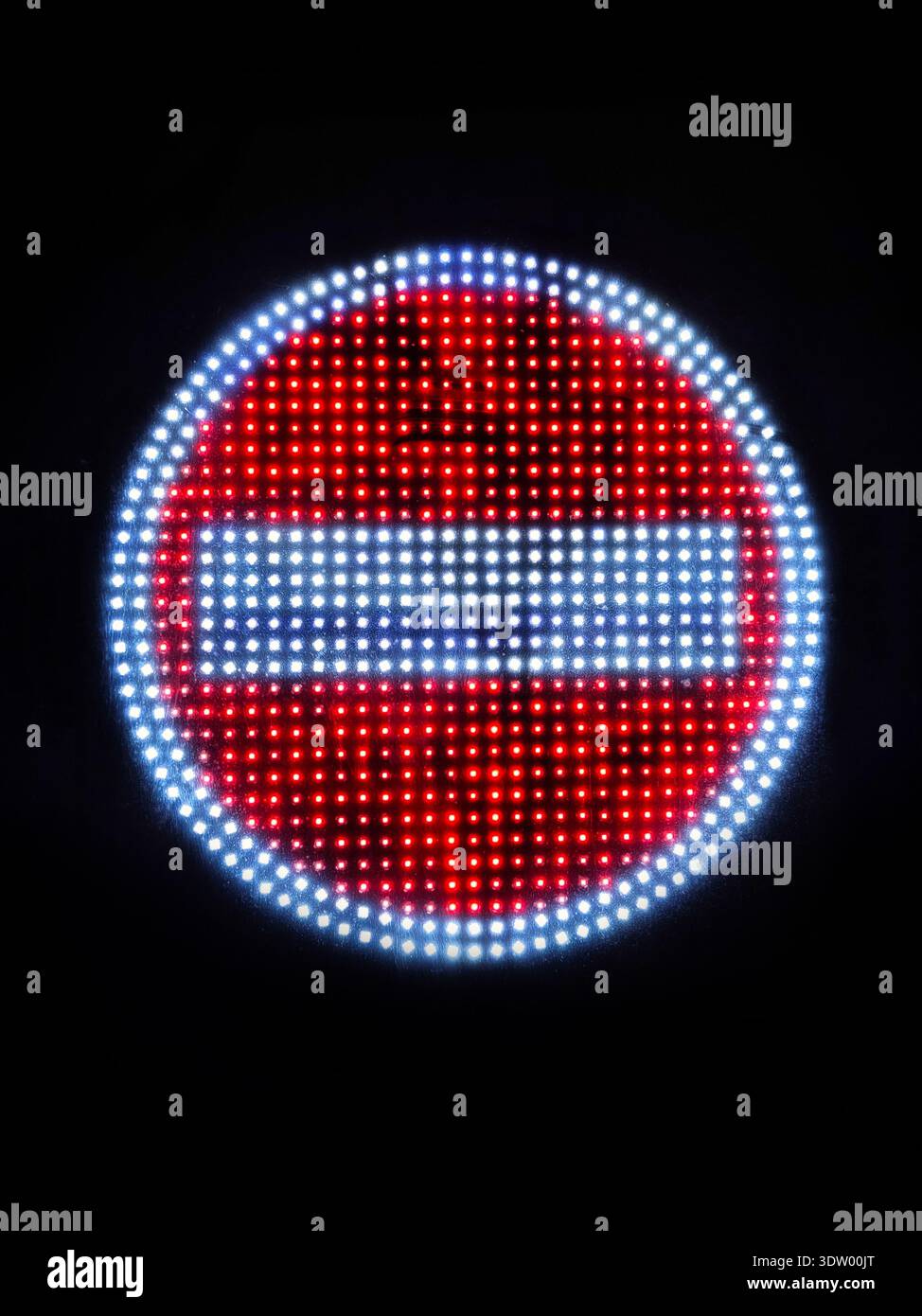 LED leuchtet im Dunkeln kein Straßenschild auf. Nahaufnahme eines rot-weißen Verkehrsverbots mit schwarzem Hintergrund, symbolisch Stockfoto