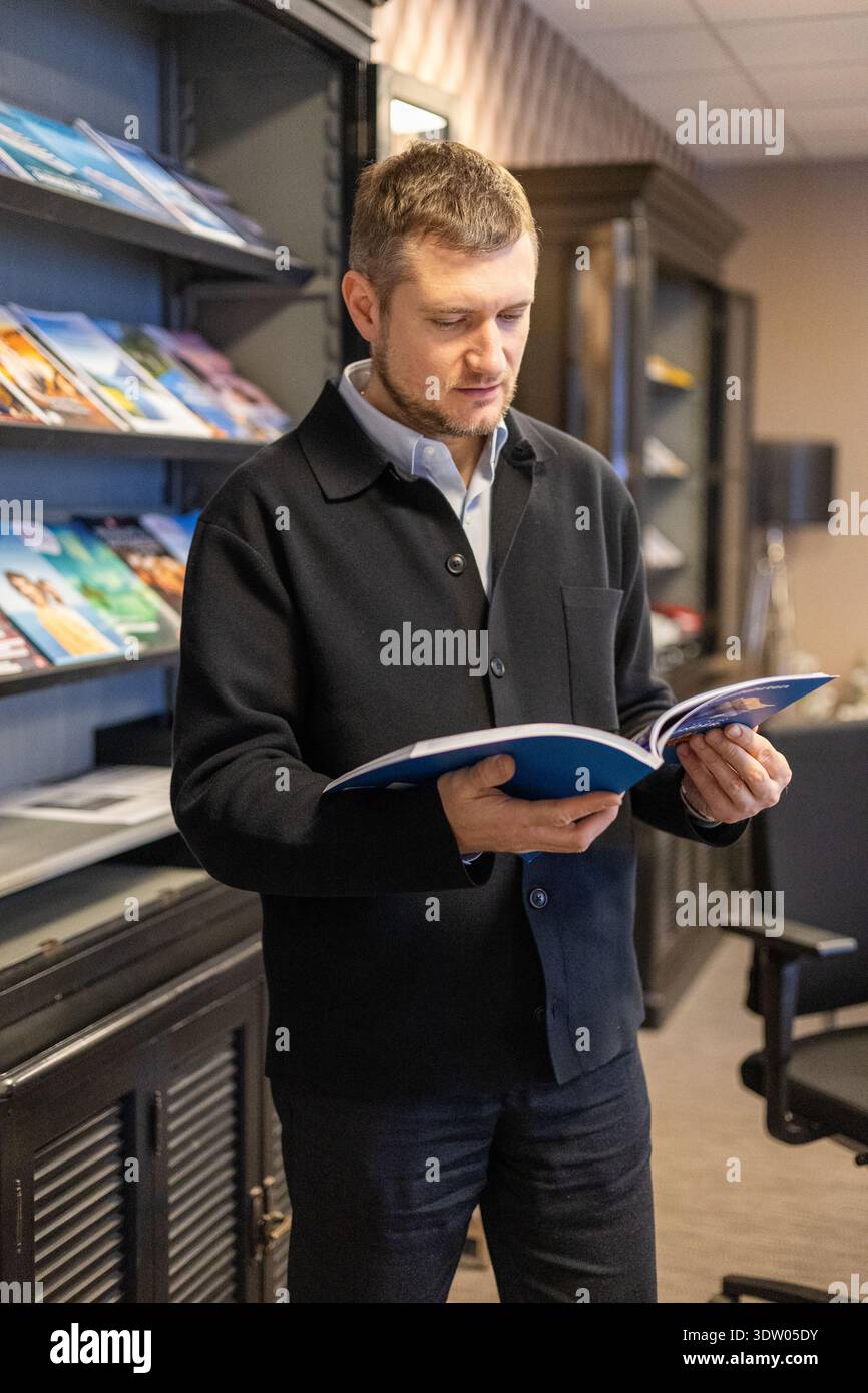 Prof. Man Liest Broschüre Im Bereich Der Bürobibliothek Mit Corporate Interior Design Stockfoto