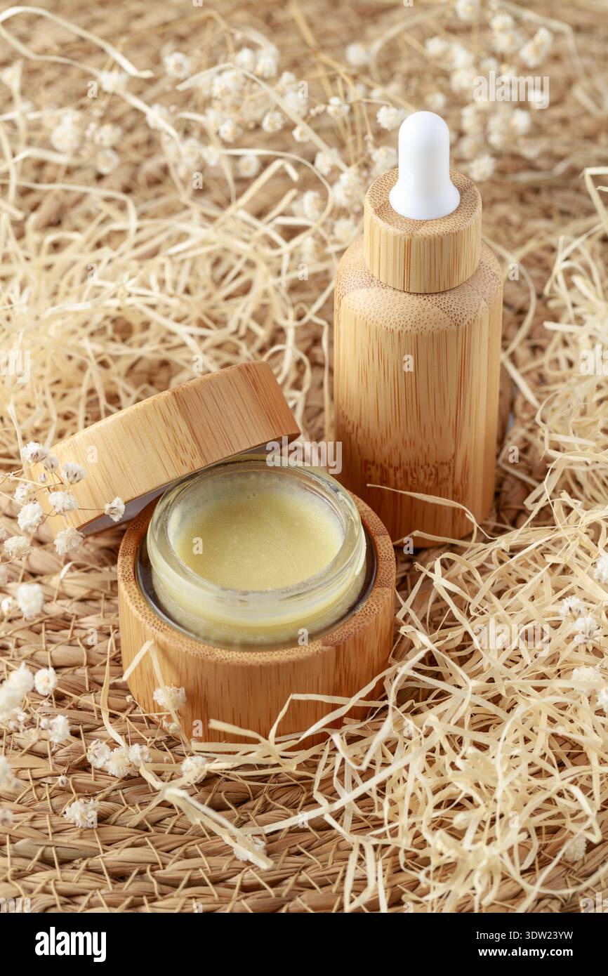 Nachfüllbare Tropfflasche aus Glas und offenes Creme- oder Salvenglas mit Bambusholz. Zero Waste Konzept für Verpackungen von kosmetischen oder medizinischen Produkten. Eco Stockfoto