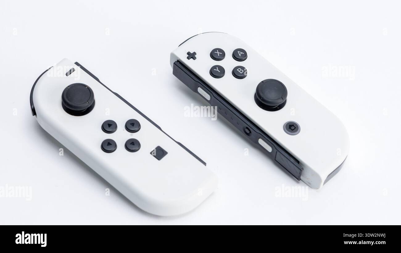 In dieser Fotoabbildung sind zwei Nintendo Switch Joy -Con-Controller auf einem schlichten Hintergrund zu sehen. Stockfoto