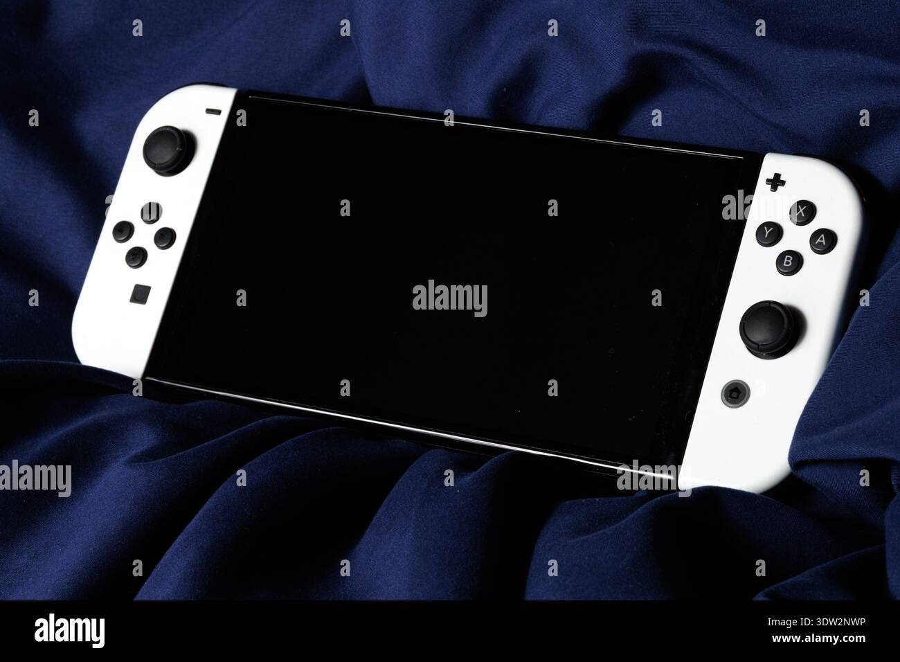 In dieser Abbildung befindet sich die Nintendo Switch-Konsole auf dunklem Stoff. Stockfoto