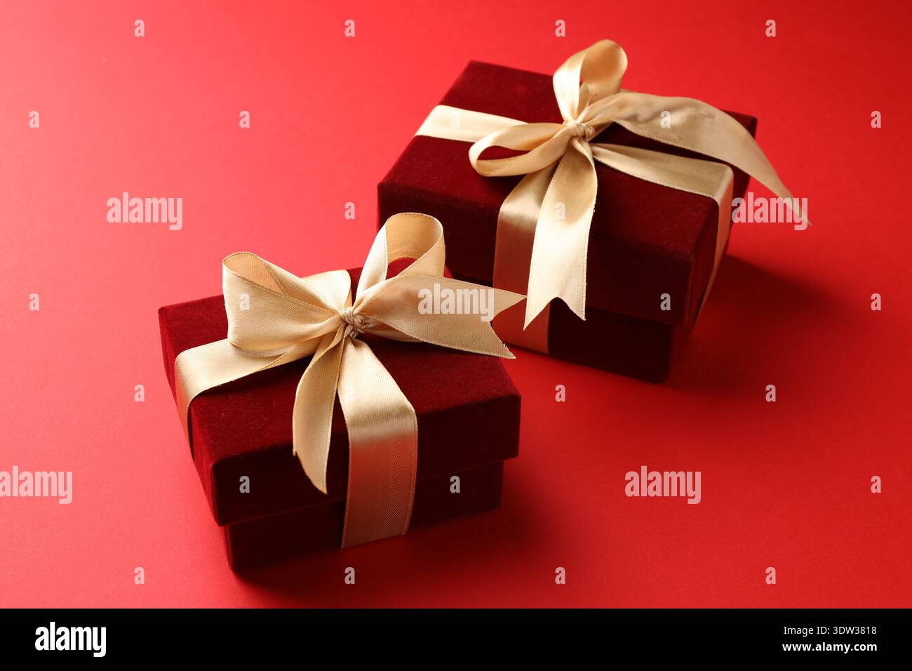 Schöne Samtgeschenkdosen auf rotem Hintergrund, Großaufnahme Stockfoto