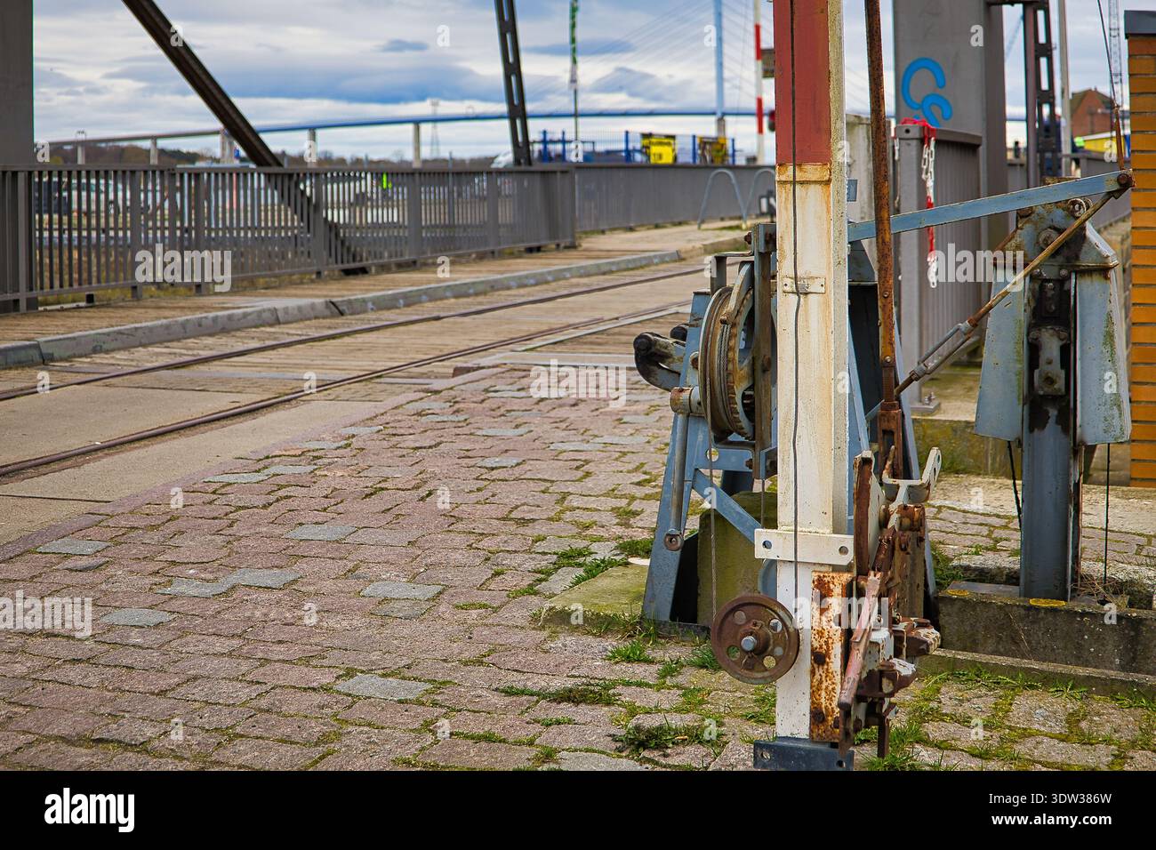 Historische Mechanik der Querkanalbrücke in Stralsund: Alte Winde- und Bahngleise mit der modernen Rügenbrücke im Hintergrund, Hafen Stockfoto