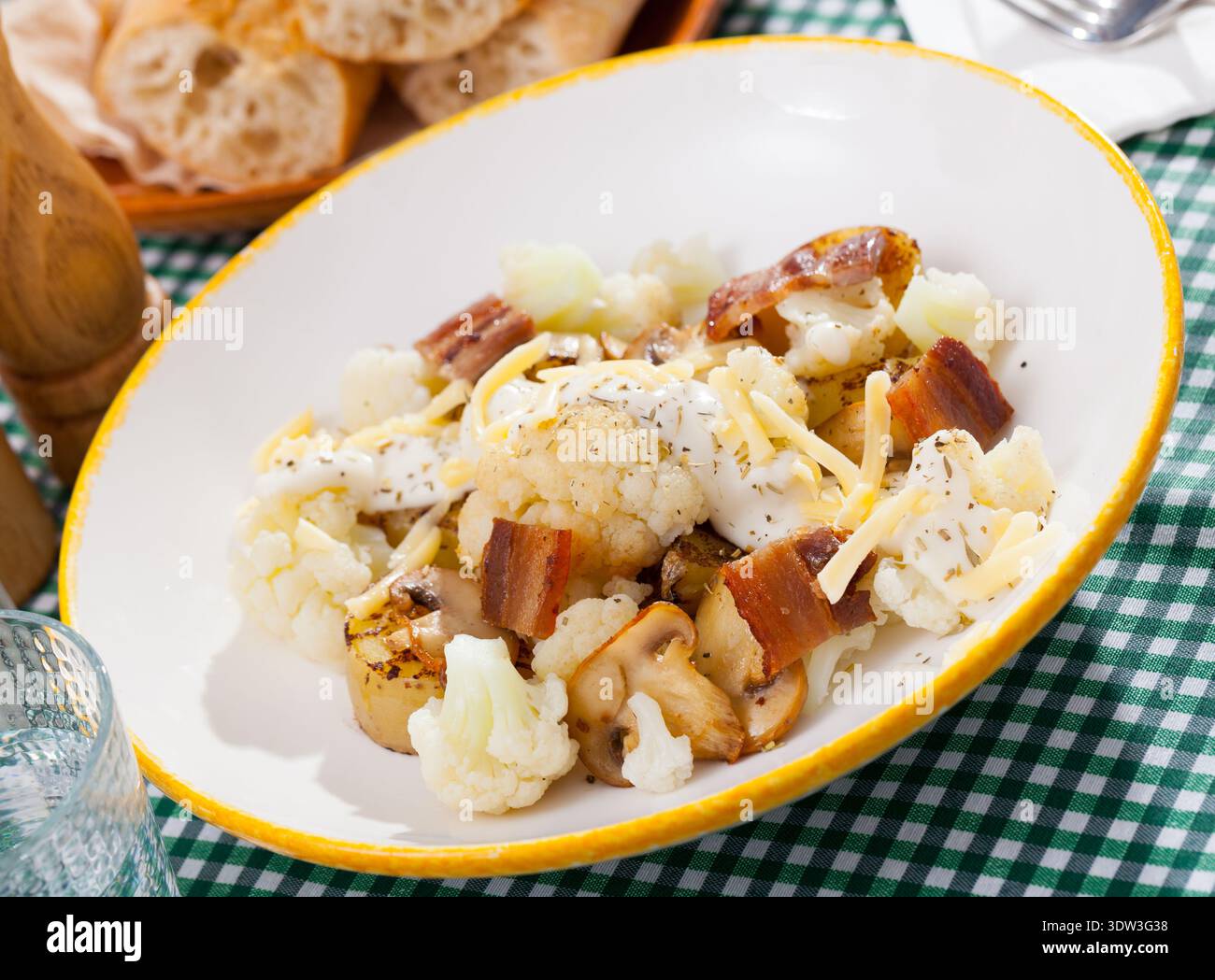 Gebackene Kartoffeln mit Blumenkohl, Speck, Käsesauce Stockfoto