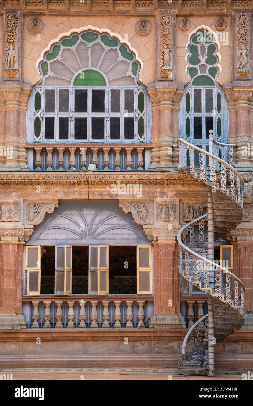 Eine wunderschön verzierte historische Gebäudefassade mit komplizierten Schnitzereien und einer Wendeltreppe in Karnataka, Indien. Stockfoto