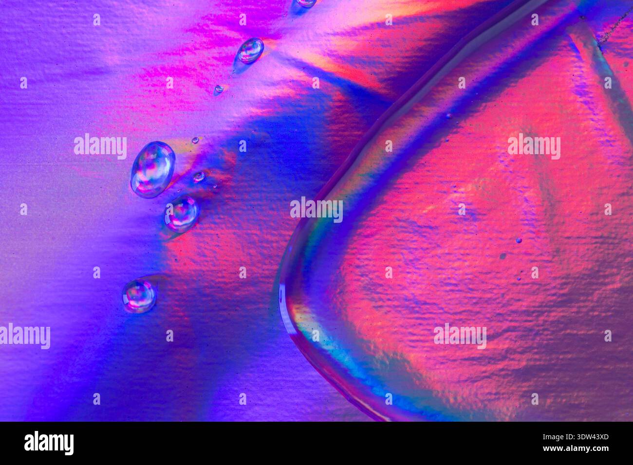 Neon-Gel-Textur mit glänzender, flüssiger Form mit leuchtenden rosa und blauen Reflexen. Glänzende Textur inspiriert von futuristischer Schönheit und Technologie Stockfoto